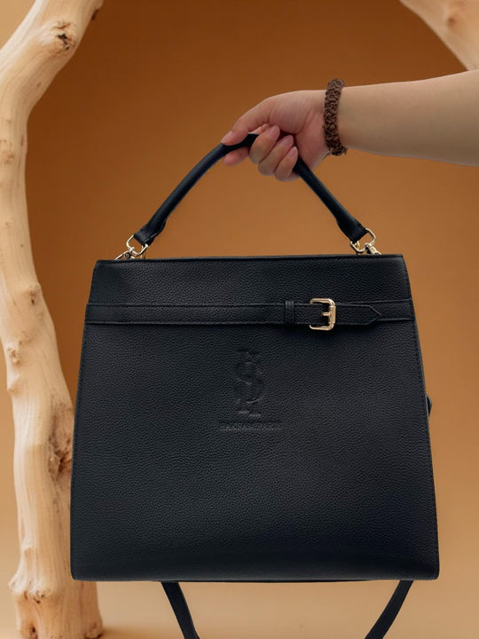 tote bag multifoction en cuir togo noir, design chic et durable, collection haksamparis tenue par la main d'une femme